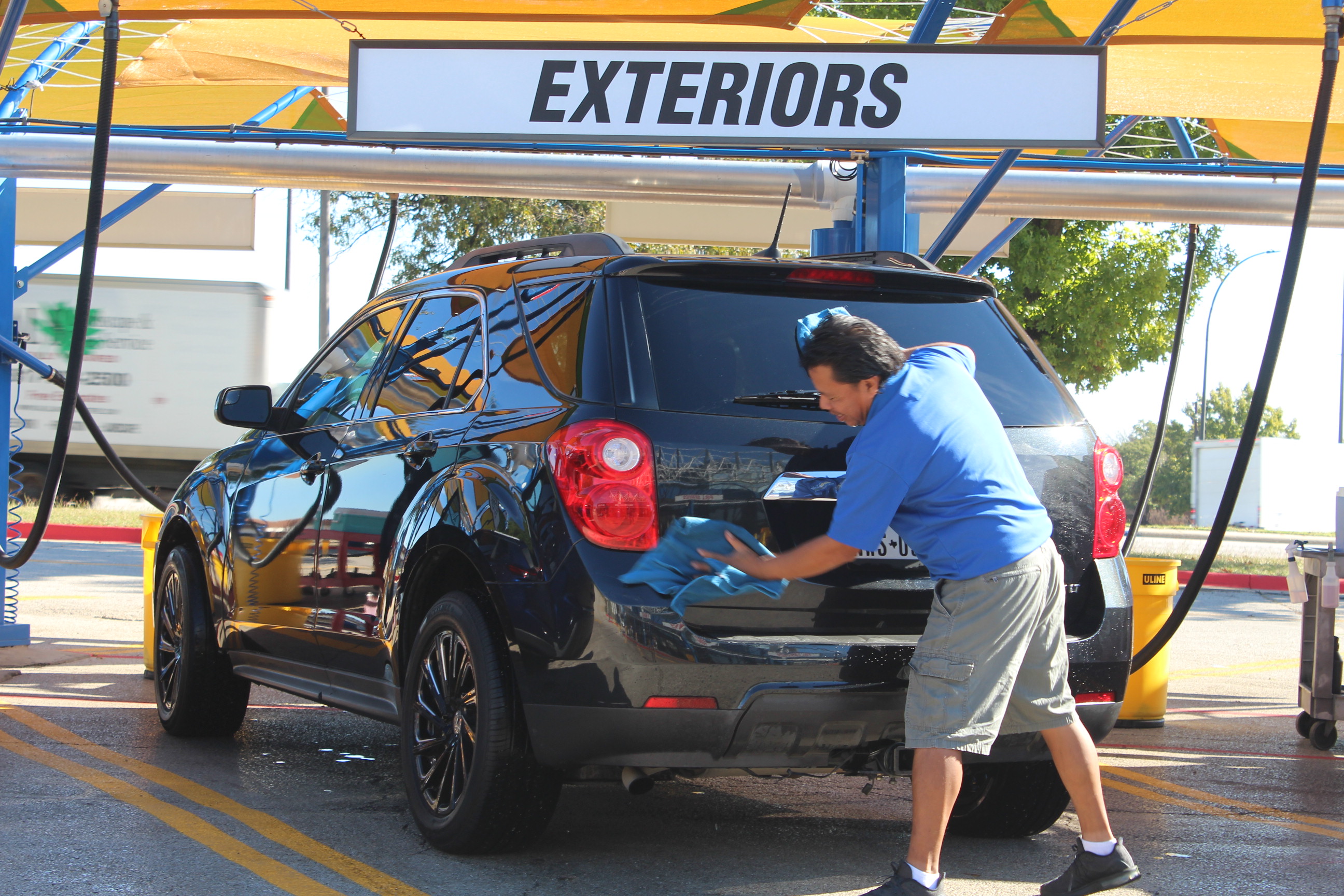 Auto Bath team member hand drying vehicle at Arlington car wash